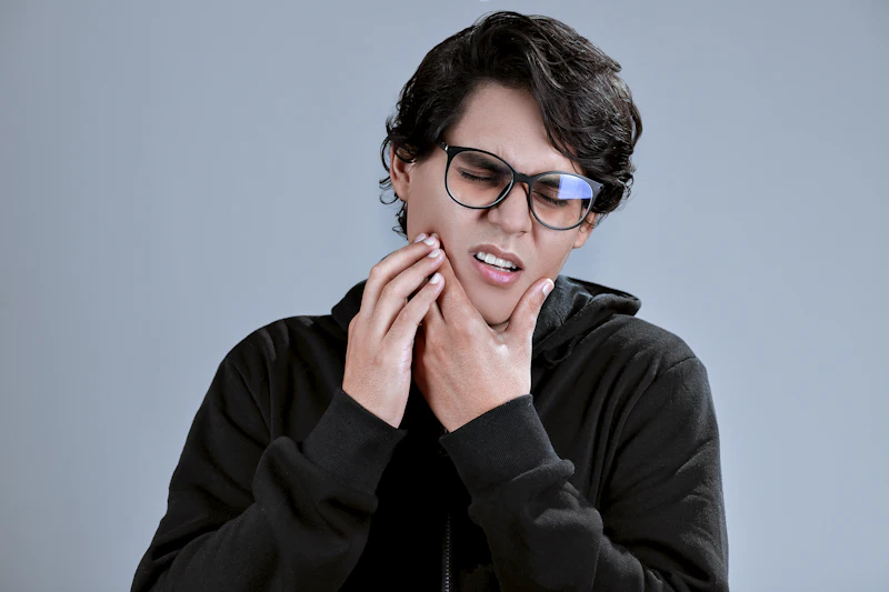 A young man holding his jaw because of a toothache