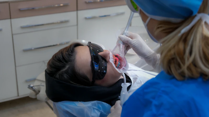 A patient in the dental chair wearing protective glasses during treatment