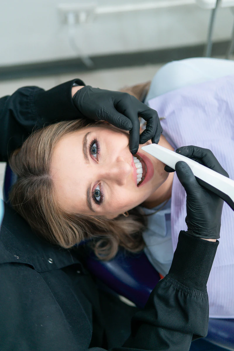 A woman smiling widely in the dental chair while the dentist works